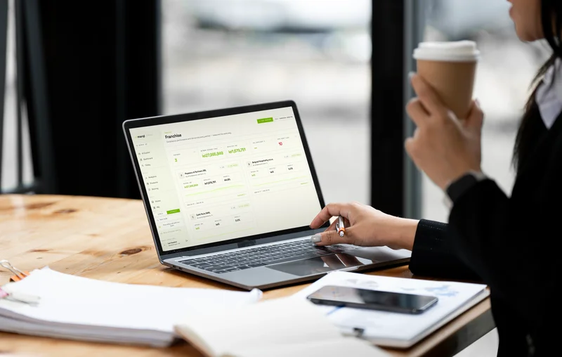 Franchise operator reviewing multi-location marql dashboard on laptop at desk